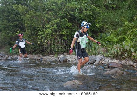 SABAH, MALEISIË - 2 APRIL.  Een racer uit een deelnemende team maakt zijn weg in een rivier in de 