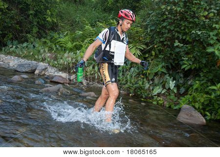 SABAH, MALEISIË - 2 APRIL.  Een racer uit een deelnemende team maakt zijn weg in een rivier in de 