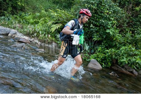 SABAH, MALEISIË - 2 APRIL.  Een racer uit een deelnemende team maakt zijn weg in een rivier in de 