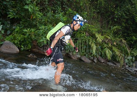SABAH, MALEISIË - 2 APRIL.  Een racer uit een deelnemende team maakt zijn weg in een rivier in de 