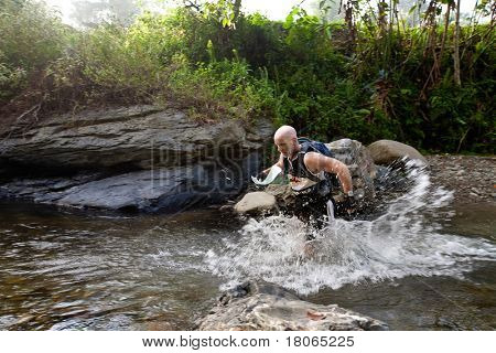 SABAH, MALEISIË - 2 APRIL. Een racer uit een deelnemende team maakt hun weg langs en over een ri