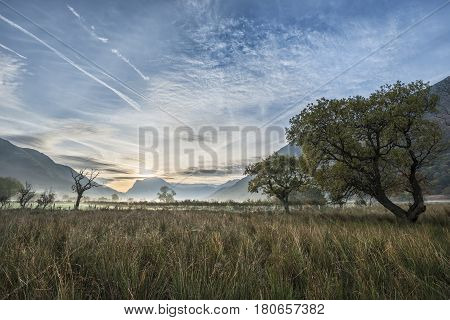 Stunning Winter Foggy Sunrise Over Countryside Around Crummock Water In Lake District England