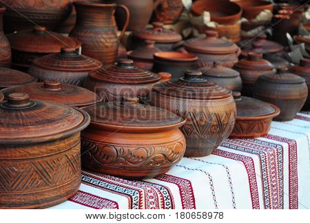 Traditional Ceramic Jugs on Decorative Towel. Showcase of Handmade Ceramic Pottery in a Roadside Market with Ceramic Pots and Clay Plates