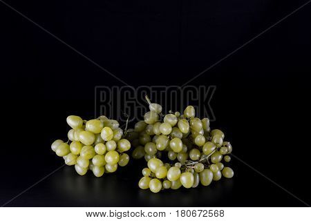 Grapes in a wicker basket on a black background