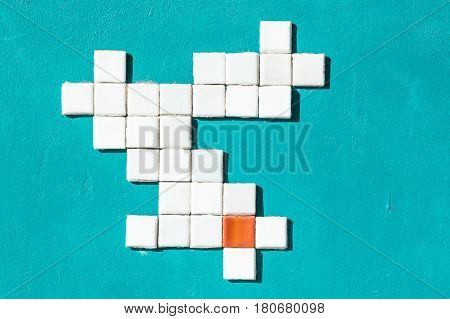 On the painted wall pattern of small tiles. Wall painted in celadon. The tiles are white and one orange.