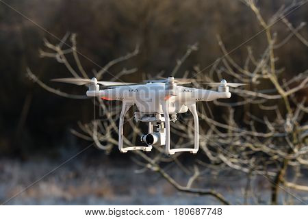 Niedernhausen Germany - February 25 2017: DJI Phantom 3 Standard Quadcopter flying in front of wintry vegetation front view closeup