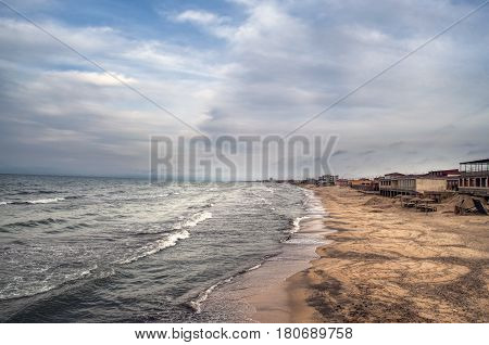 Sunset At The Sea Shore Of A Beach With Rocks And Stormy Waves, Beautiful Seascape At Caspian Sea Ab