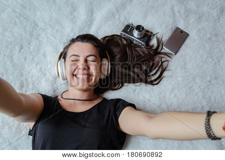 woman taking selfie in bed while listening music