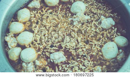 Boil the noodles with eggs and meatballs.