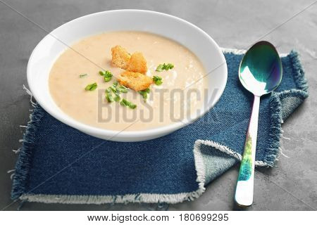 Delicious cream soup with bread on table
