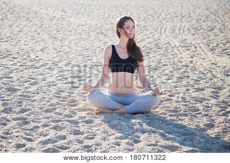 beautiful girl engaged in fitness Yoga on the beach
