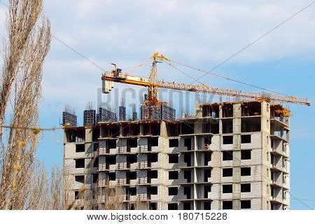 High crane on the construction of a multifamily urban residential building