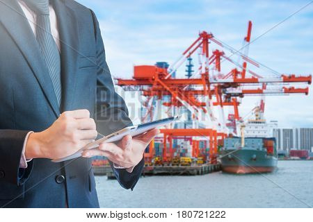 Double Exposure Of Businessman Touching Tablet For Analyze And Checking Stock At Logistics Port Back