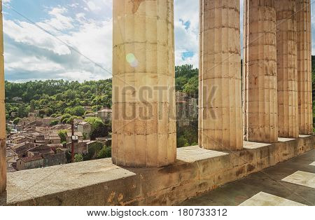 Look at largentiere through the pillars of the neoclassical courthouse in the Ardeche region of France