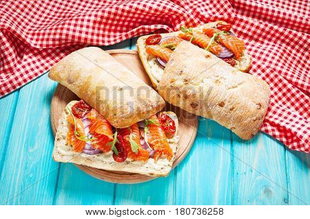 sandwich with smoked salmon on blue wooden table.