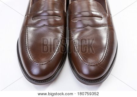 Footwear Concepts. Pair of Stylish Brown Penny Loafer Shoes Against White Background. Placed Together Closely. Horizontal Image Composition