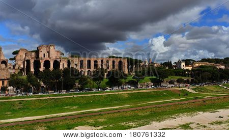 Ancient ruins of Circus Maximus and Palatine Hill Imperial Palace with stormy clouds in the historic center of Rome