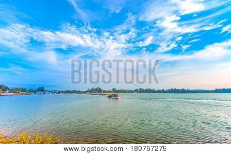 calmness seashore with fishing boat over the sea and cloudy blue sky