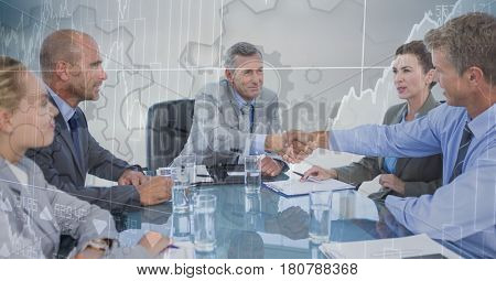 Digital composite of Business meeting with behind gear and chart graphic overlay against grey background