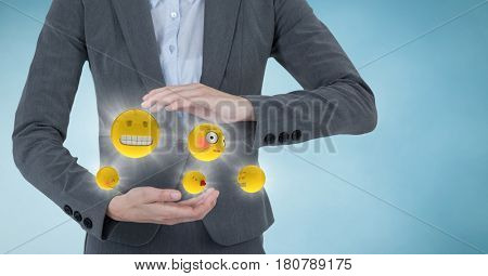 Digital composite of Mid section of business woman with emojis and flares between hands against blue background with clou