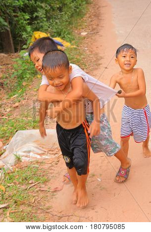 Phu Quock , Vietnam, Januar 15, 2017: Unidentified vietnamese happy preteen kids children walking along the road, laughing and playing in Phu Quock island, Vietnam, Januar 15, 2017.