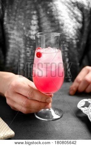 Woman with glass of delicious wine spritzer at table