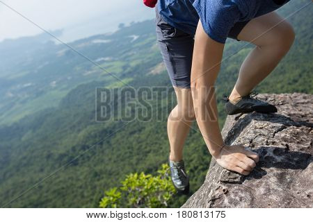 success young woman rock climber on mountain peak