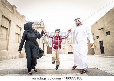 Arabic family playing with child in the old Dubai