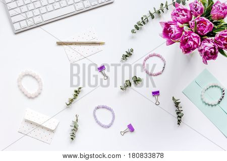 Spring pink flowers on workdesk at home ofiice white background top view