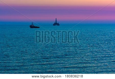 Oil platform in sea. Beautiful sunset calm sea
