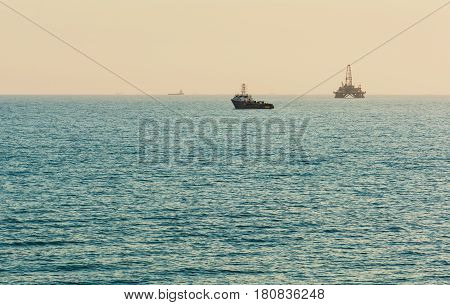 Oil platform in sea. Beautiful sunset calm sea