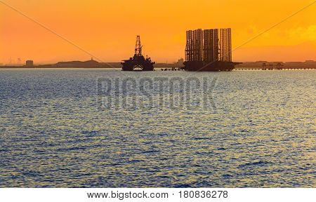 Oil platform in sea. Beautiful sunset calm sea