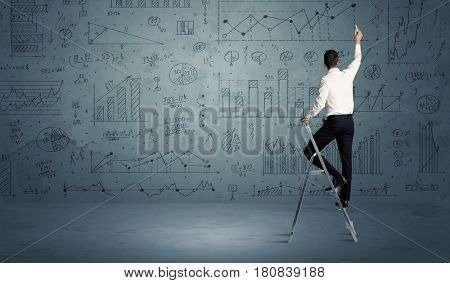 A businessman in modern stylish elegant suit standing on a small ladder and drawing pie and block charts on grey wall background with exponential progressing curves, lines, circles,  blocks, numbers