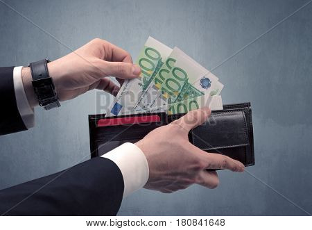 Businessman's hand in suit takes out eruo from his wallet