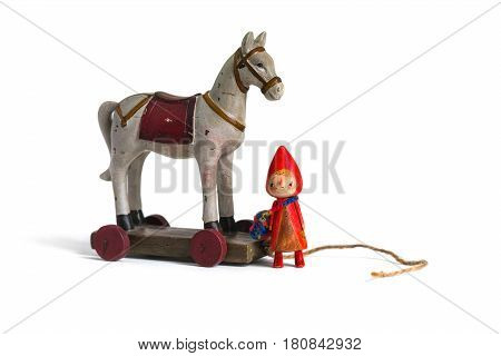 Vintage children's toy wooden horse and a doll on a white background