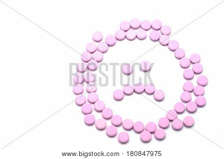 Sad unhappy face of pink pills on white background. Tablets of drug for asthma treatment