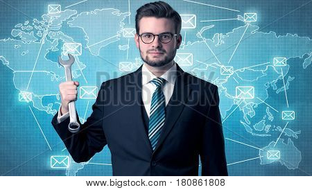 Businessman holding tool with global map graphic on the background