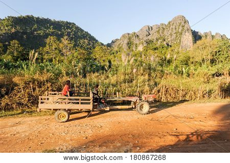 People Traveling In A Tractor Near The Village Of Vang Vien