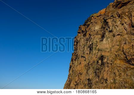 Rocky Mountain side with bright blue sky in the background