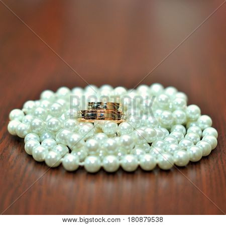 Close-up of wedding rings on wooden background