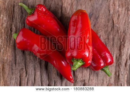 Red chilly pepper on wooden black background. Red hot chili peppers. Domestic cultivation extra hot chilli burn.