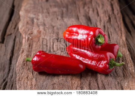 Red chilly pepper on wooden black background. Red hot chili peppers. Domestic cultivation extra hot chilli burn.
