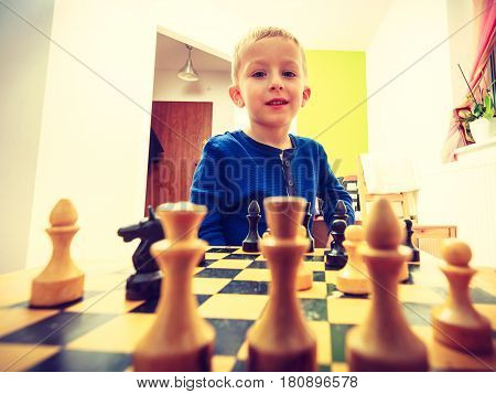 Intelligent smart ass kids games good for brain intelligence concept. Young kid boy playing chess and having fun.