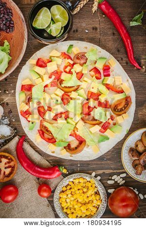 Tortilla With Salad Over It, Surrounded By Ingredients.