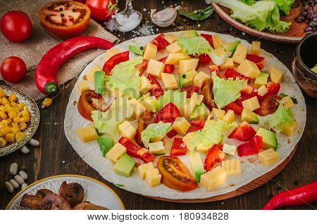 Tortilla With Salad Over It, Surrounded By Ingredients.