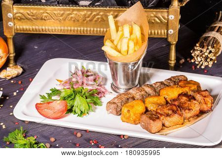 A shish kebab from chicken, a shish kebab from mutton and a shish kebab from veal, fried on coals