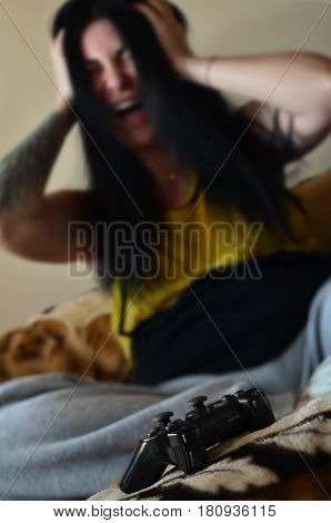 The Young Girl Sitting On The Couch Is Disappointed By The Loss During The Game On The Game Console