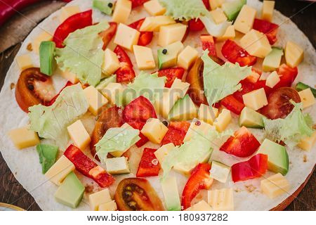 Tortilla With Salad Over It, Surrounded By Ingredients.