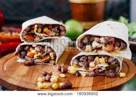 Nice Vegetarian Burrito Over Black Table On Wooden Board.