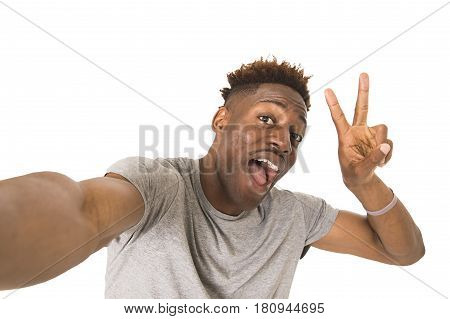young afro american man smiling happy taking selfie self portrait picture with mobile phone looking excited having fun posing cool isolated in white background in communication technology concept
